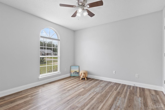 5732 Dove Dr, Pace, FL 32571 - spare room featuring wood finished floors, baseboards, ceiling fan, and a textured ceiling