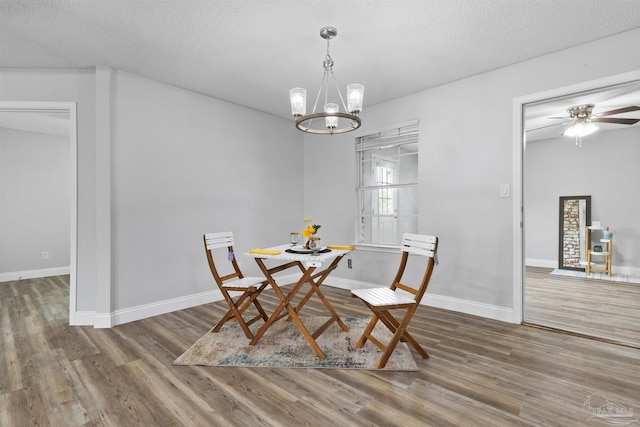 5732 Dove Dr, Pace, FL 32571 - dining space with wood finished floors, a chandelier, baseboards, a textured ceiling, and ceiling fan