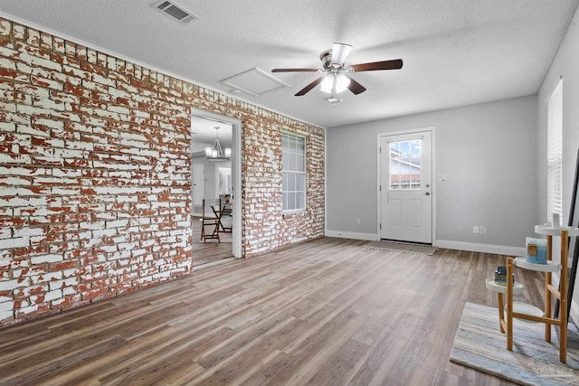 5732 Dove Dr, Pace, FL 32571 - spare room with ceiling fan, wood finished floors, brick wall, a textured ceiling, and baseboards