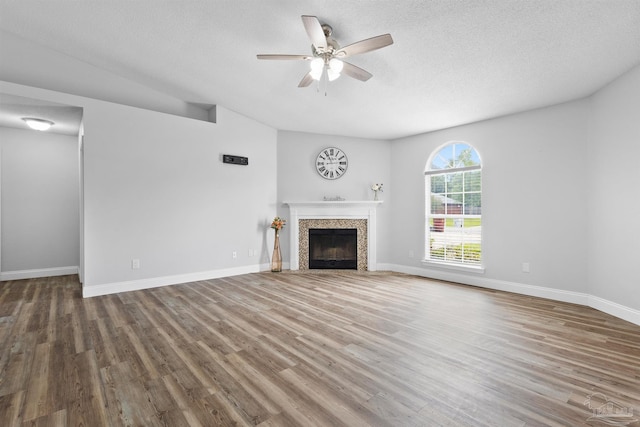 5732 Dove Dr, Pace, FL 32571 - unfurnished living room featuring ceiling fan, wood finished floors, a textured ceiling, a fireplace, and baseboards