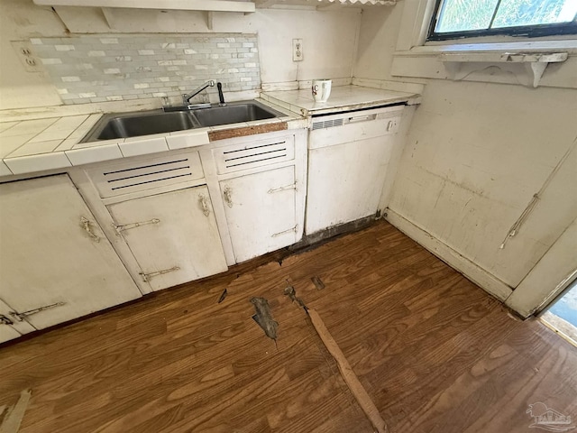 kitchen featuring dishwasher, dark wood-type flooring, sink, backsplash, and tile countertops