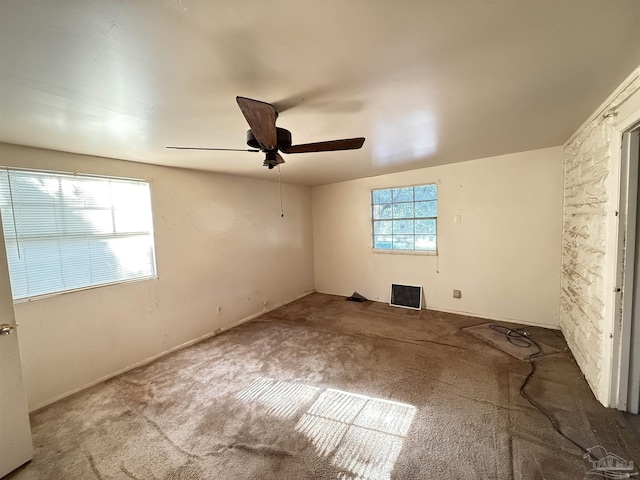 carpeted empty room featuring ceiling fan and plenty of natural light