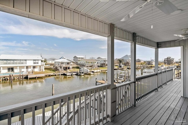 wooden terrace with ceiling fan, a dock, and a water view