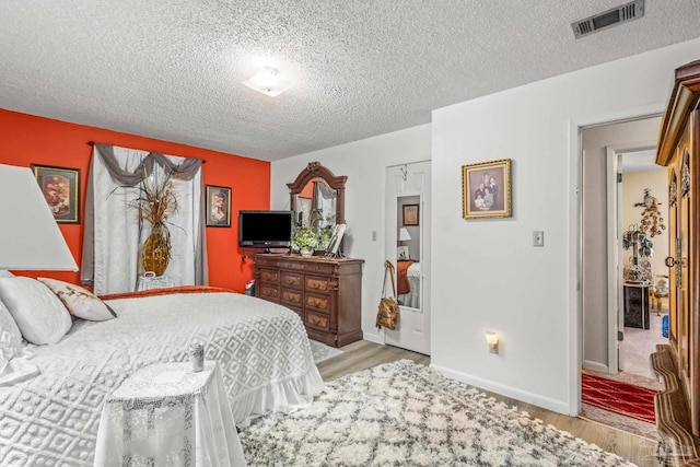 bedroom with a textured ceiling, light hardwood / wood-style floors, and a closet