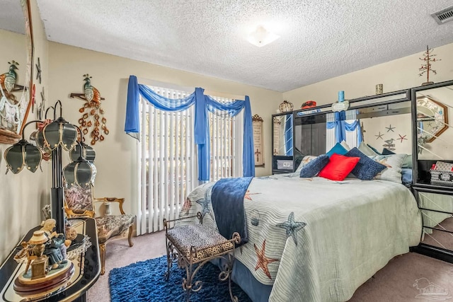 bedroom with a textured ceiling and carpet flooring