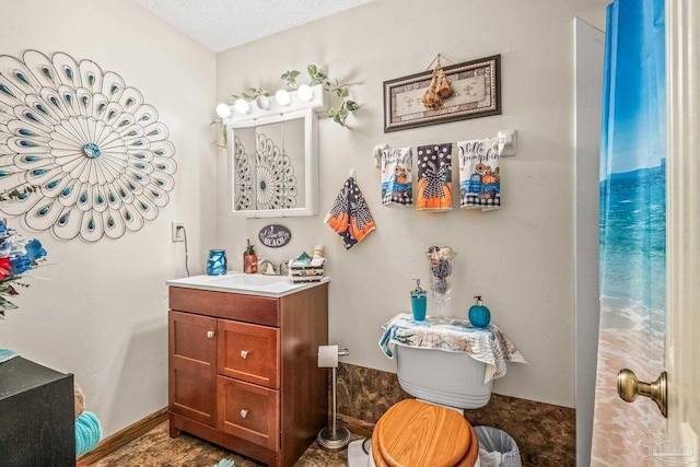 bathroom featuring vanity, toilet, and a textured ceiling