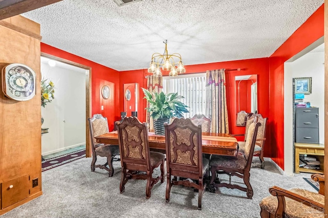 dining area featuring carpet floors, a notable chandelier, and a textured ceiling