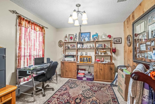 home office with an inviting chandelier, carpet flooring, and a textured ceiling