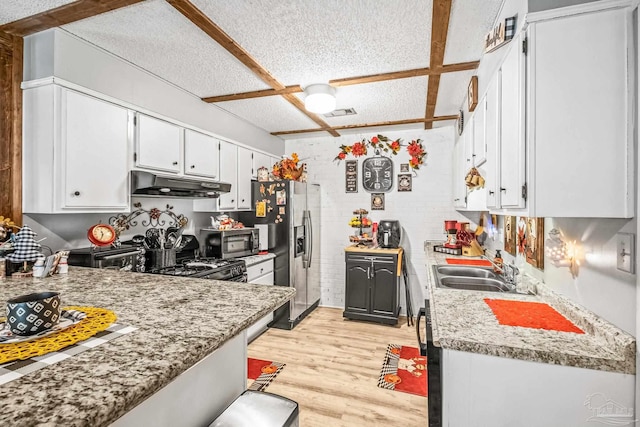 kitchen with sink, a textured ceiling, white cabinetry, stainless steel appliances, and light wood-type flooring