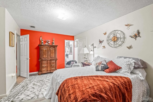 bedroom featuring a textured ceiling and light hardwood / wood-style floors