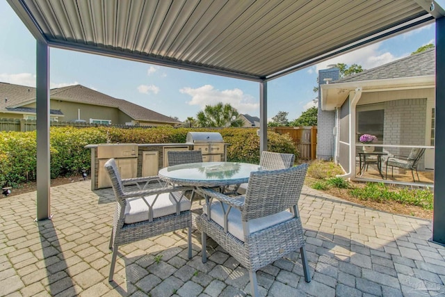 view of patio with area for grilling, outdoor dining space, a grill, and fence