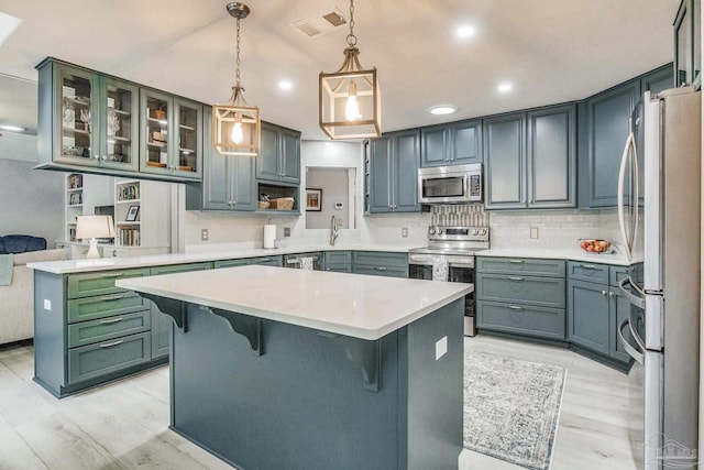 kitchen with a kitchen breakfast bar, backsplash, visible vents, and appliances with stainless steel finishes