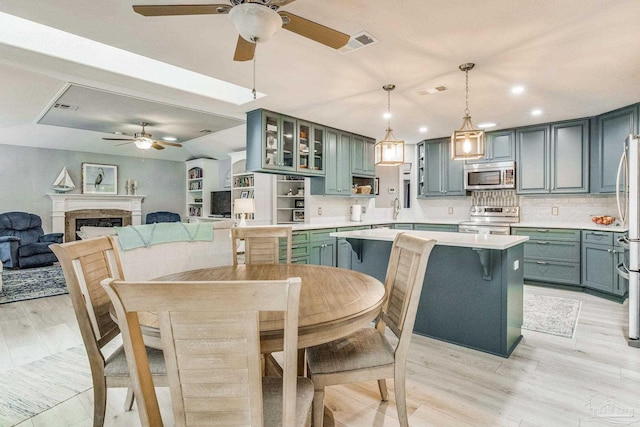 dining room featuring visible vents, a ceiling fan, recessed lighting, light wood-style floors, and a fireplace