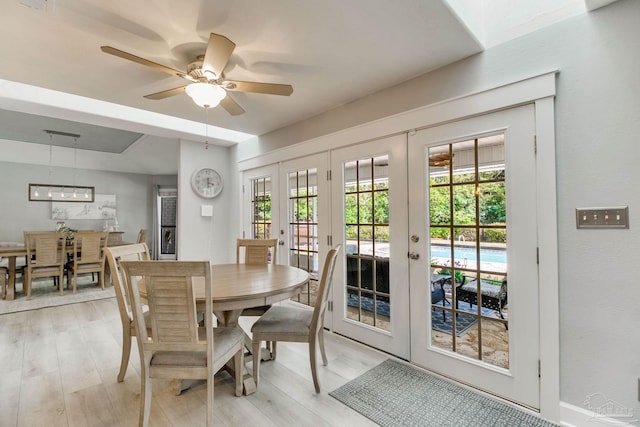 dining room featuring a wealth of natural light, french doors, light wood-style floors, and a ceiling fan