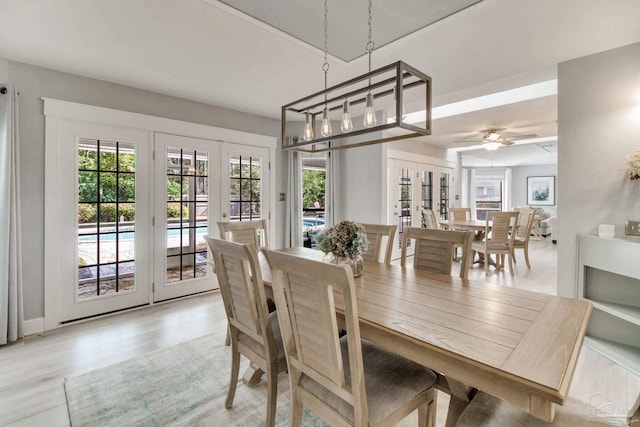 dining area with a ceiling fan, light wood-style flooring, and french doors