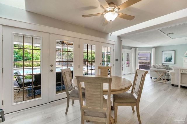 dining area with light wood-type flooring, french doors, a healthy amount of sunlight, and a ceiling fan