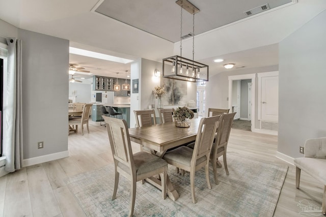 dining space featuring light wood-type flooring, baseboards, and visible vents