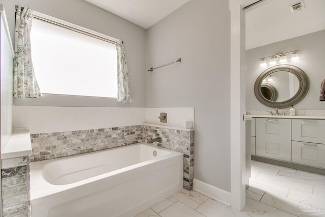 bathroom with vanity, baseboards, visible vents, a garden tub, and marble finish floor