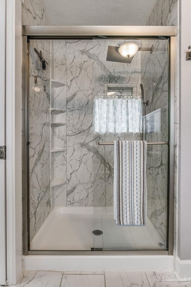 full bathroom with marble finish floor and a marble finish shower