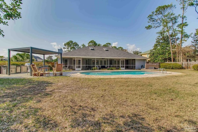 rear view of property with a fenced in pool, fence, a lawn, a sunroom, and a patio