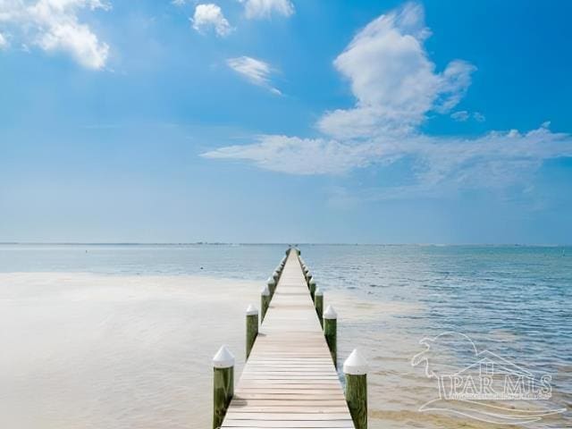 view of dock featuring a water view and a beach view