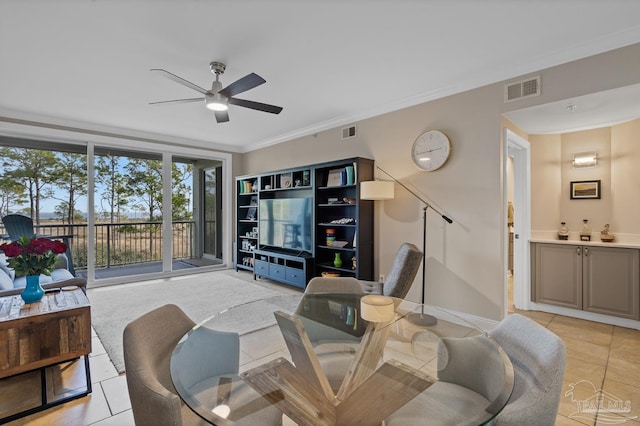 living room with ceiling fan, ornamental molding, and light tile patterned floors