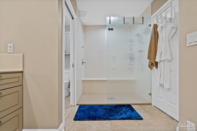 bathroom featuring tile patterned flooring, a shower, vanity, and toilet