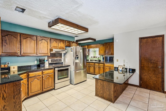 kitchen featuring sink, light tile patterned flooring, stainless steel appliances, and a textured ceiling