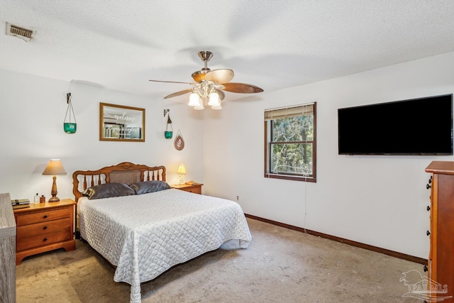 carpeted bedroom featuring ceiling fan and a textured ceiling