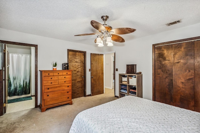 bedroom featuring a textured ceiling, light colored carpet, and ceiling fan