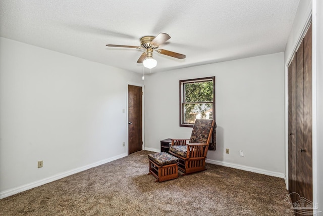 living area featuring a textured ceiling, carpet floors, and ceiling fan