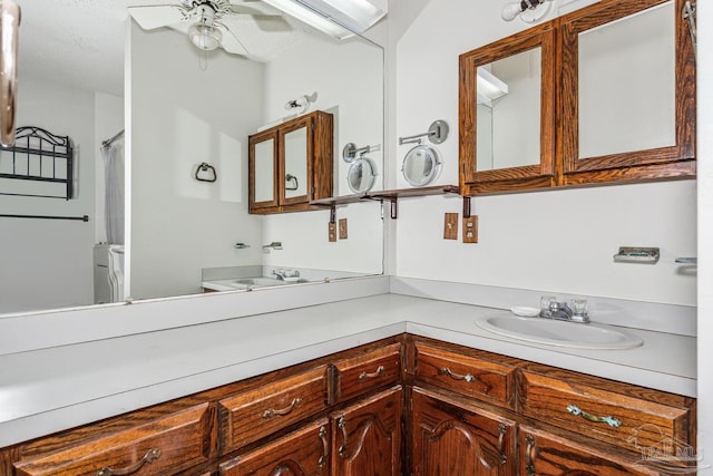 bathroom featuring ceiling fan, vanity, and a textured ceiling