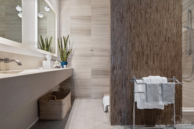 bathroom featuring tile patterned flooring, vanity, tile walls, and walk in shower