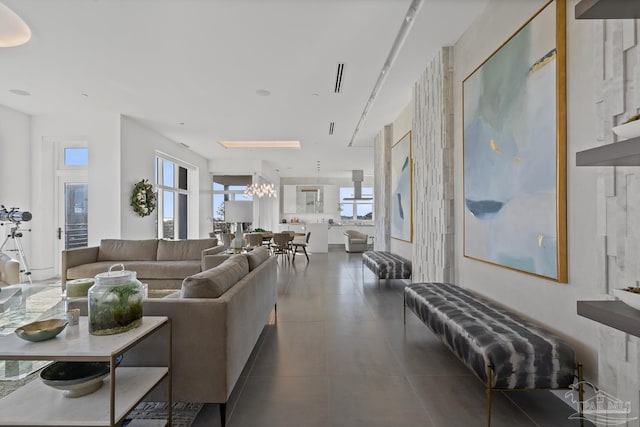 tiled living room featuring an inviting chandelier