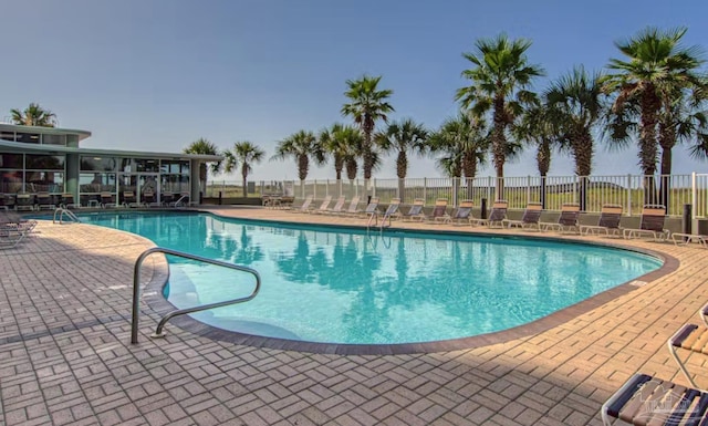 pool with a patio and fence