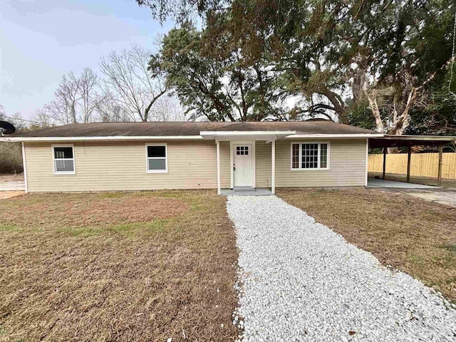 single story home with a front lawn and a carport