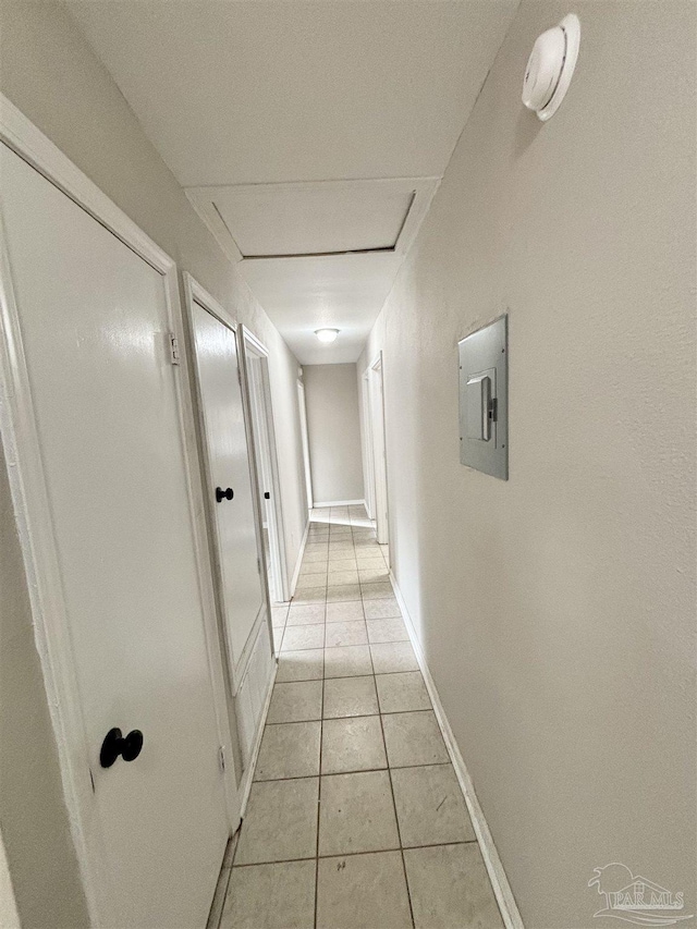 hall with light tile patterned flooring and electric panel