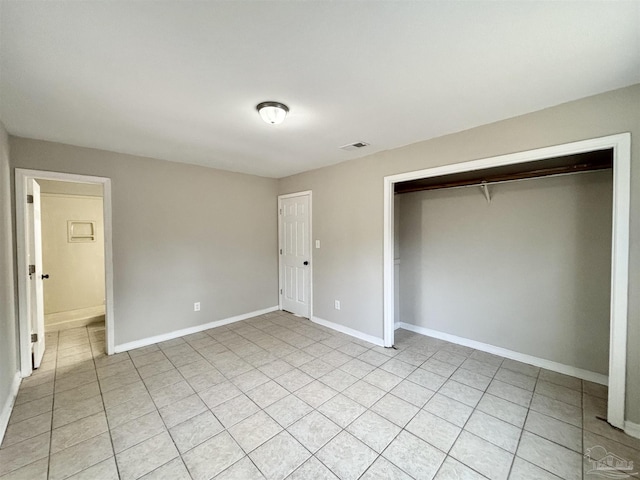 unfurnished bedroom featuring light tile patterned flooring and a closet