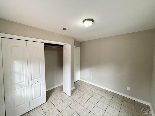 unfurnished bedroom featuring a closet and light tile patterned flooring