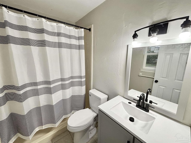 bathroom featuring toilet, tile patterned flooring, a shower with shower curtain, a textured wall, and vanity