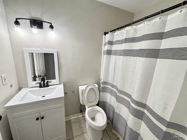 bathroom featuring tile patterned floors, toilet, baseboards, a shower with shower curtain, and vanity