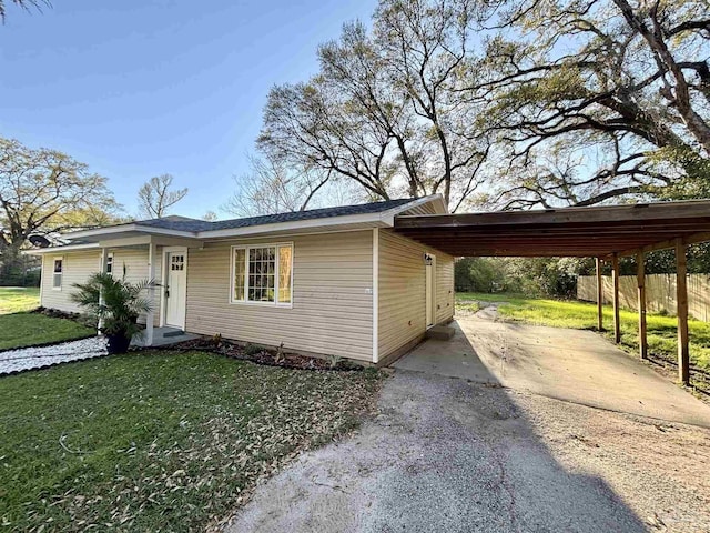 ranch-style home with fence, a front lawn, driveway, and an attached carport