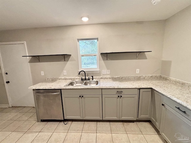 kitchen featuring sink, light tile patterned floors, gray cabinetry, light stone counters, and stainless steel dishwasher