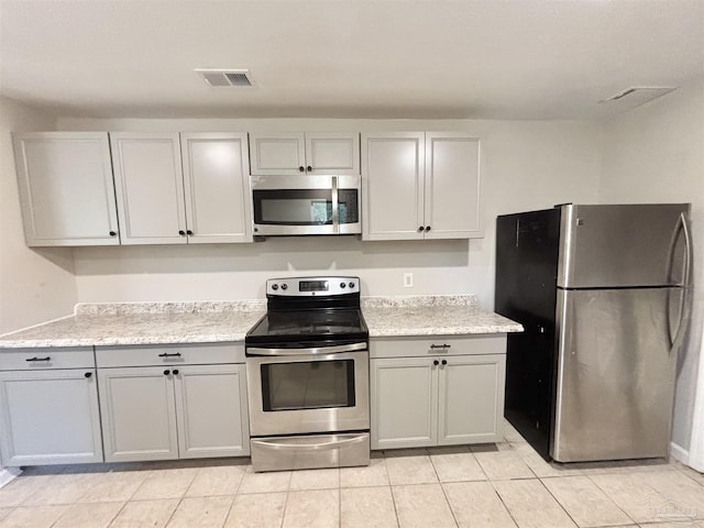 kitchen featuring appliances with stainless steel finishes and light stone counters