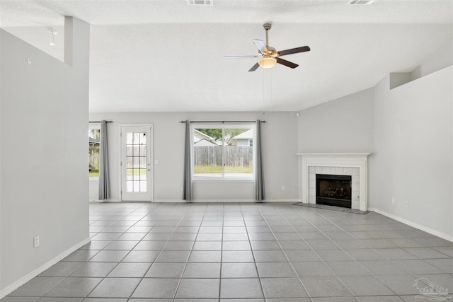 2252 Valle Escondido Dr, Pensacola, FL 32526 - unfurnished living room featuring light tile patterned floors, ceiling fan, a tile fireplace, and lofted ceiling