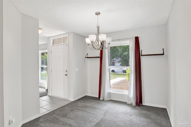 2252 Valle Escondido Dr, Pensacola, FL 32526 - entryway featuring a textured ceiling, baseboards, carpet flooring, and a notable chandelier