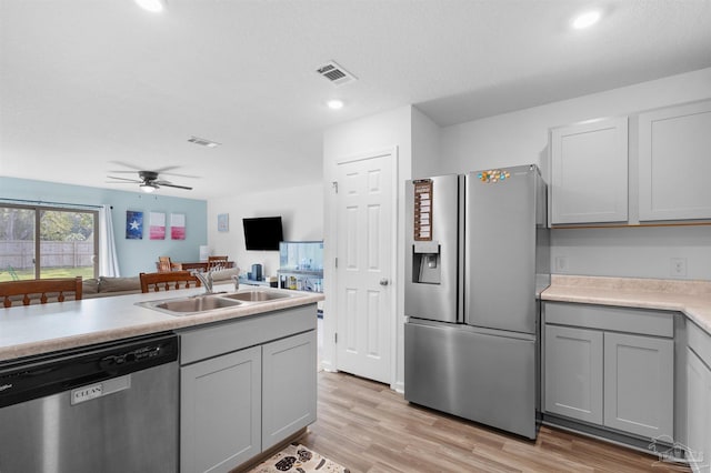 8743 Schooner Ln, Pensacola, FL 32507 - kitchen featuring gray cabinetry, a sink, light wood finished floors, a ceiling fan, and appliances with stainless steel finishes