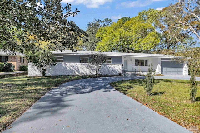 ranch-style home featuring a garage and a front lawn