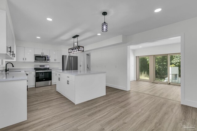 unfurnished bedroom featuring a barn door, light hardwood / wood-style flooring, and a closet