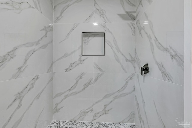 interior details featuring tiled shower